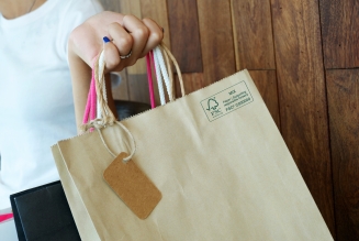 close up of a hand holding a paper shopping bag with FSC MIX Label