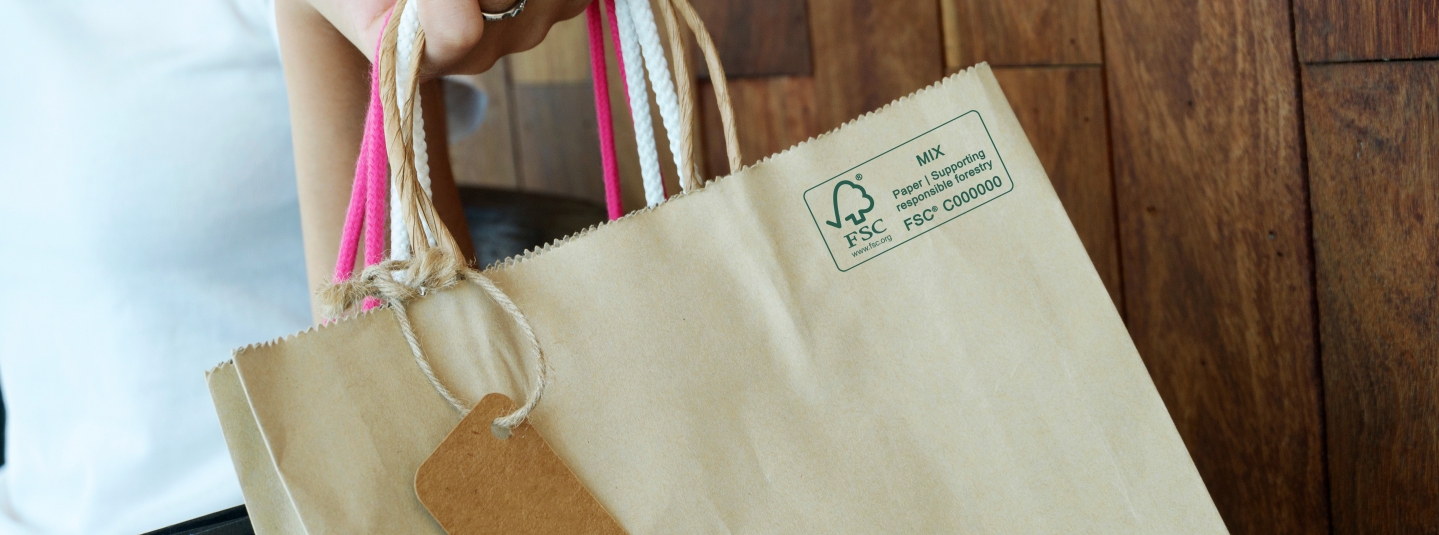 close up of a hand holding a paper shopping bag with FSC MIX Label