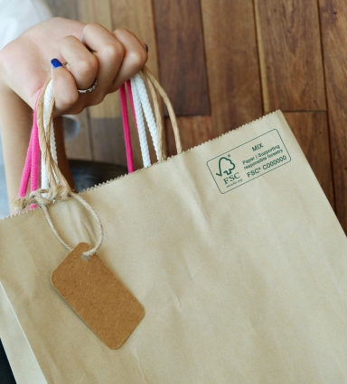 close up of a hand holding a paper shopping bag with FSC MIX Label