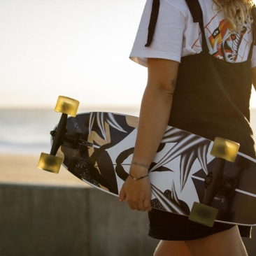 Personne marchant un skate à la main en bord de plage